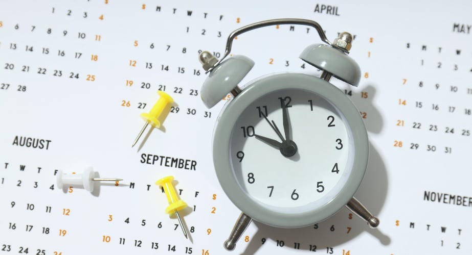 paper calendar with an alarm clock over the month of october