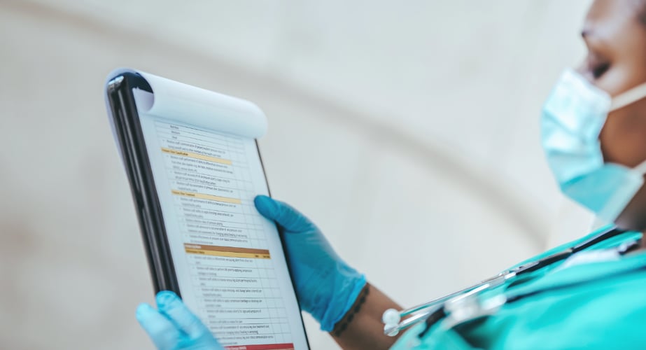 Image of a patient clinical chart on a clipboard held by a nurse