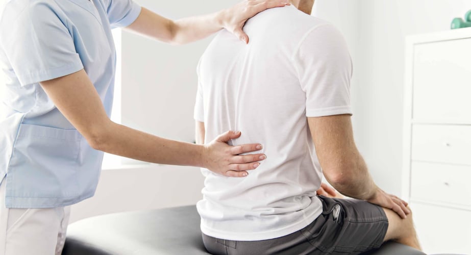 image of a doctor assessing a patients back pain