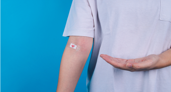 image of a patients body showing their arm with a band-aid over their elbow vein